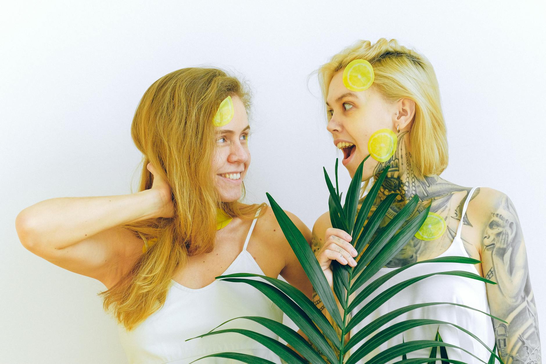 Two women smiling with lemon slices, expressing joy and connection