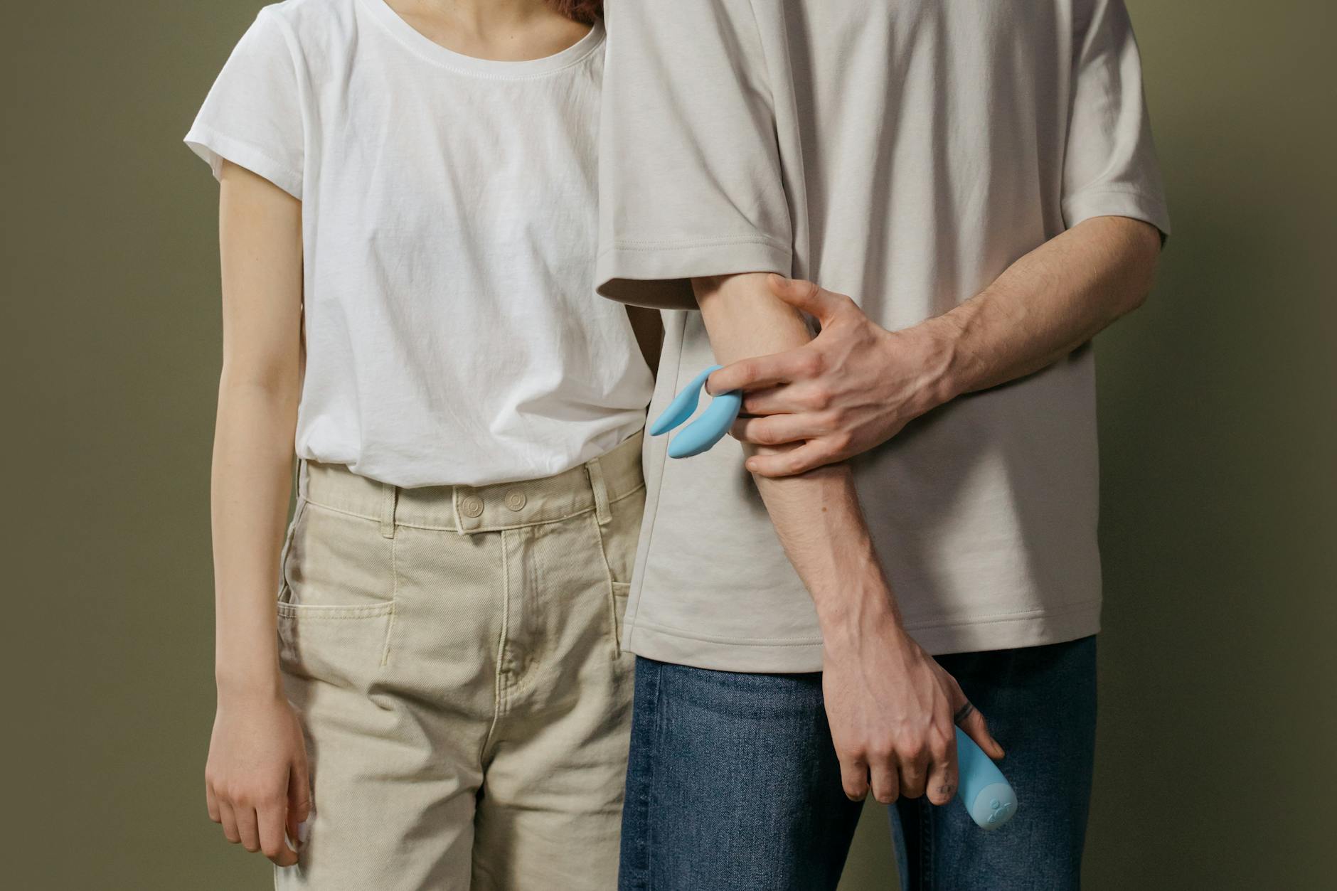 手に持たれた橙色のバイブレーター、紫色の背景に対して現代的な感性を表現